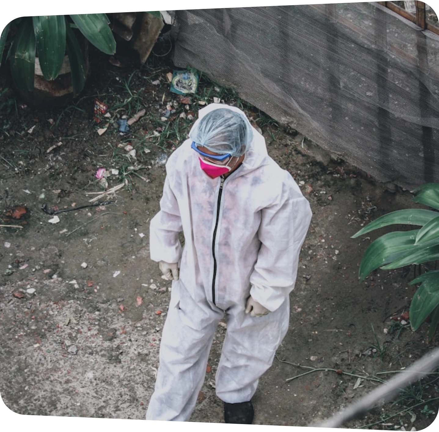Technician in a protective suit inspecting an outdoor site